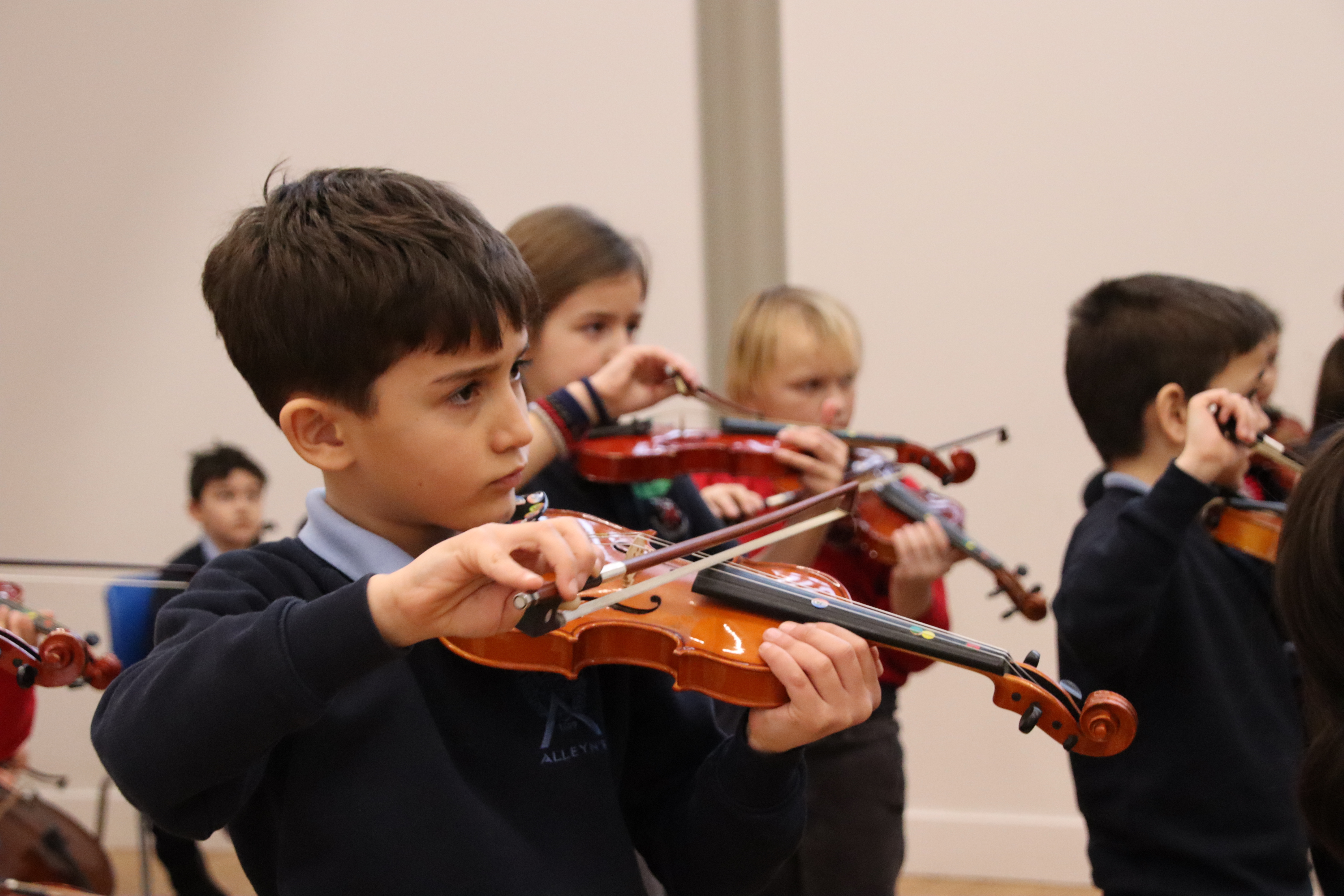 Junior school music students playing instruments.