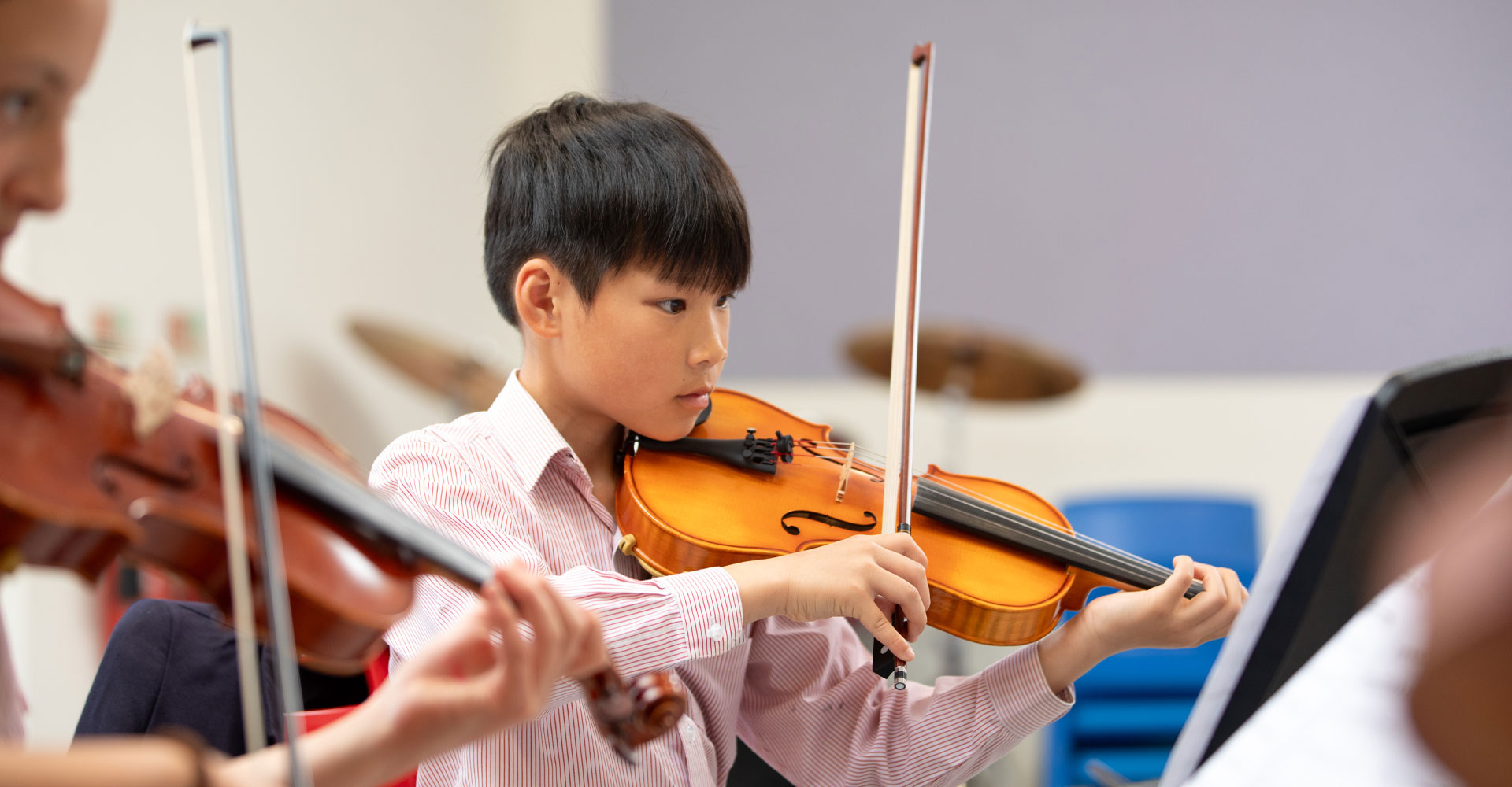 Junior school music students playing instruments.